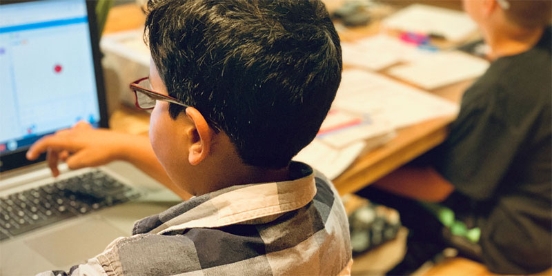 A child working at a computer on a programming exercise